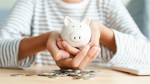 Child hands holding piggy bank