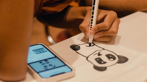 Teen drawing animal on paper