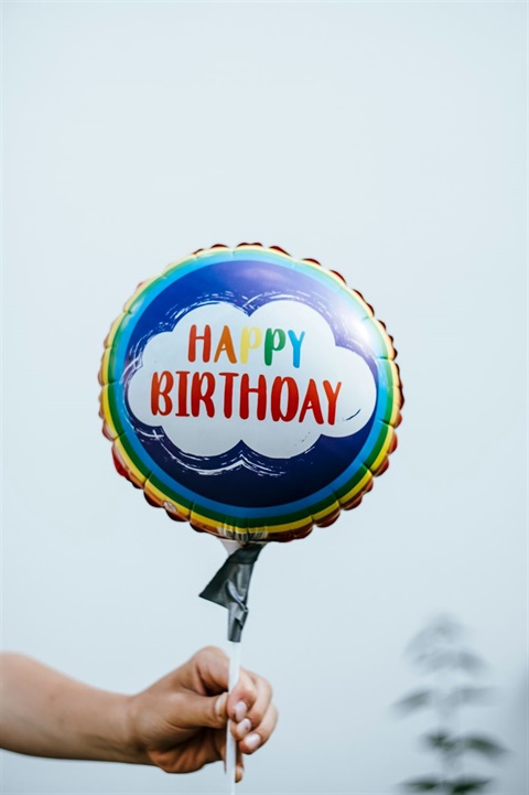 hand holding a colorful balloon with the words 