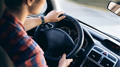 Image of a teenage boy behind the wheel of a car