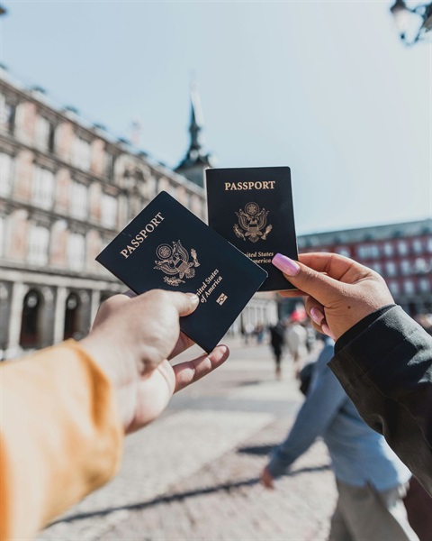 people holding their US passports in front of a building