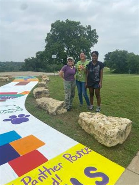 Students standing next to a creative mural project at Atatiana Carr-Jefferson Community Center at Hillside